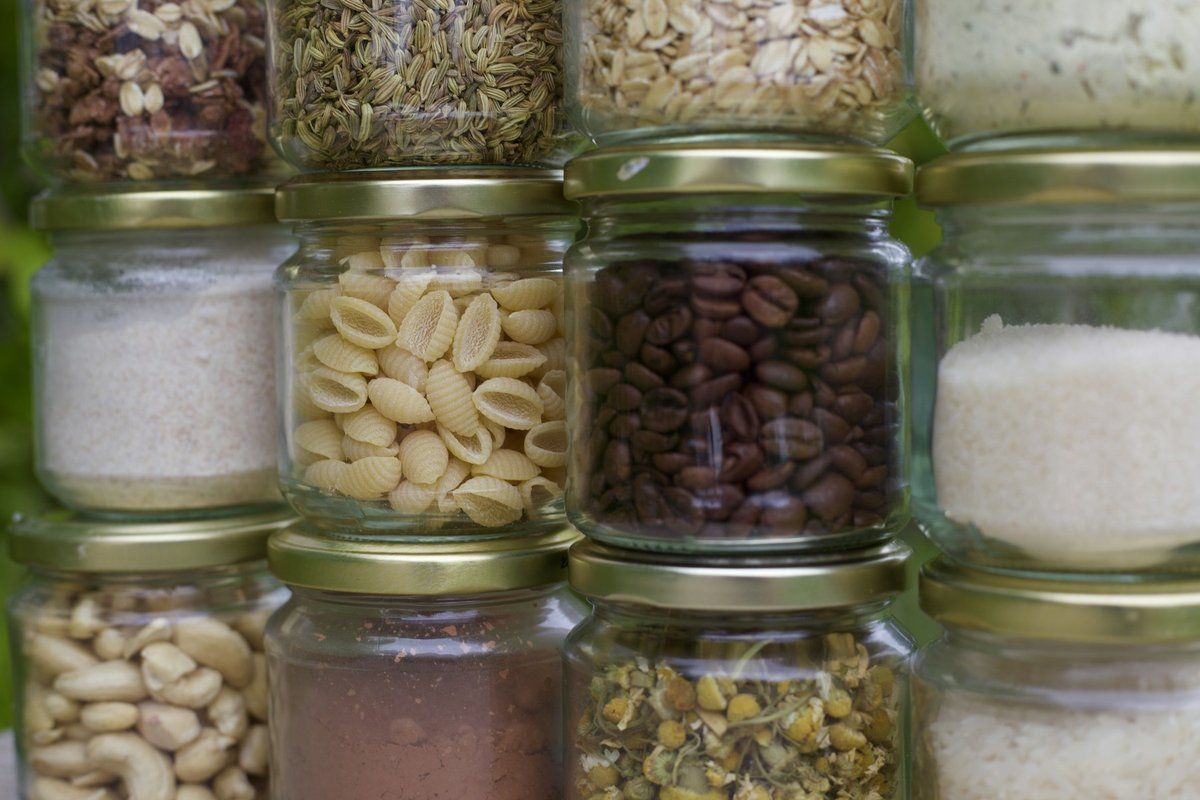 Bocaux en verre alignés contenant des pâtes, des haricots et des graines