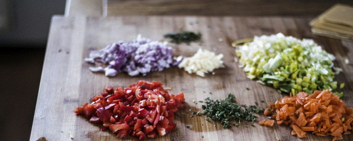 Légumes émincés disposés en petits tas sur une planche à découper